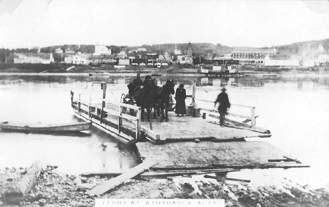A wooden ferry landing on a dock on a river with a two-horse-drawn wagon and several people beginning to disembark. A small town can be seen of the opposite shore across the river.